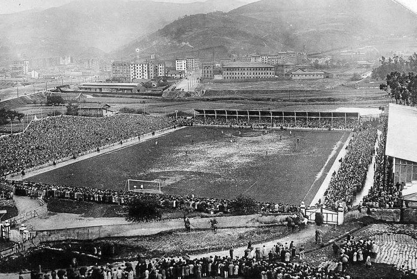 El viejo San Mamés durante un partido, con las gradas llenas y los montes de Bilbao al fondo